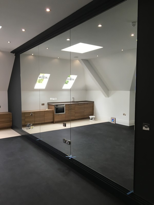 Frameless glass partition in loft conversion by Westcombe Park glaziers
