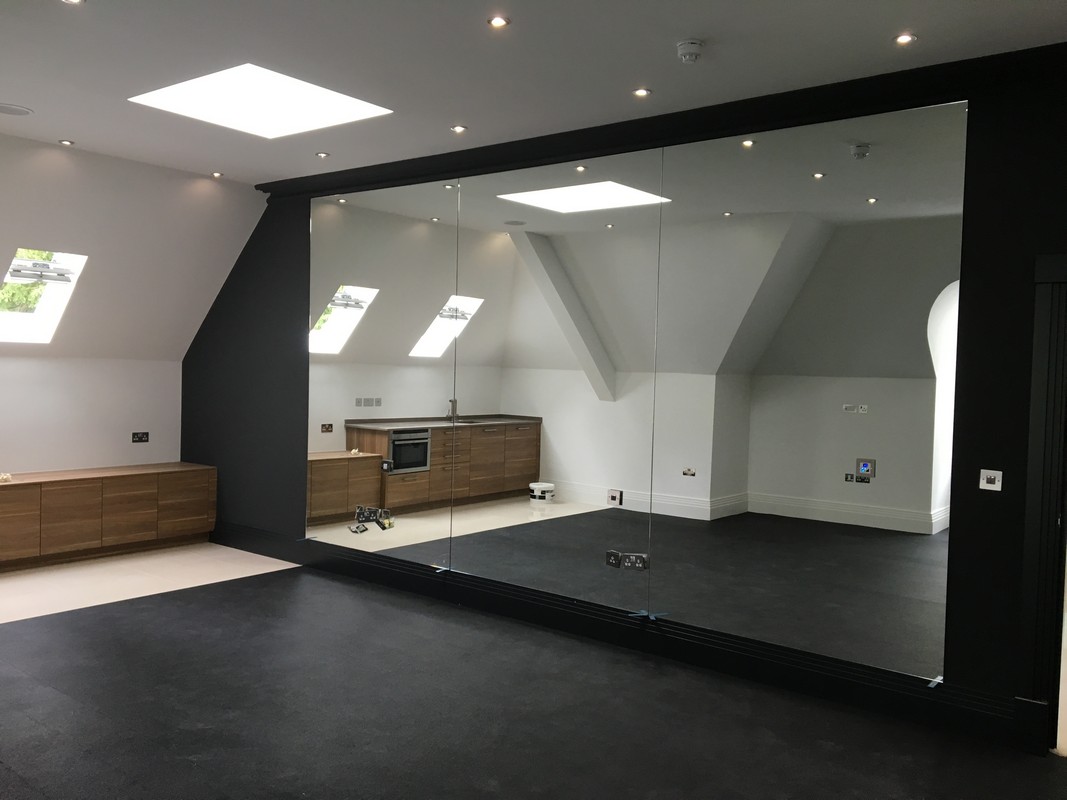 Frameless glass wall dividing loft conversion in Westcombe Park